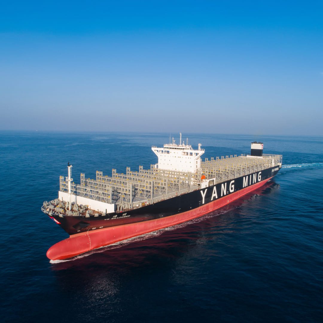 Aerial view of the Yang Ming container ship YM Willpower navigating the open blue sea.