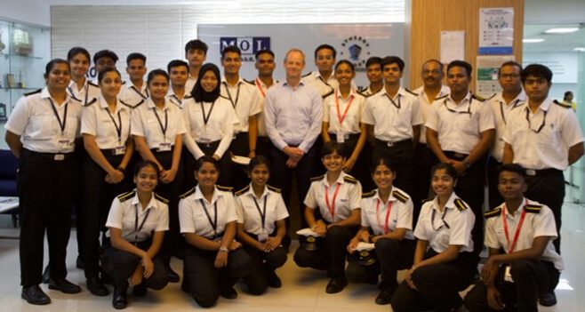 Synergy Marine Group maritime cadets in uniform posing for a group photo with Jesper Kristensen, Group CEO, Synergy Marine Group.